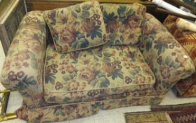A two seater sofa with beige ground foliate and floral patterned upholstery