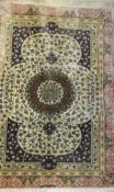 A Persian silk rug, the central circular medallion in cream, eau de nil, blue, green and cinnamon on