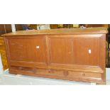 An early 20th Century teak hanging cabinet with two panels over three drawers,
