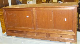 An early 20th Century teak hanging cabinet with two panels over three drawers,