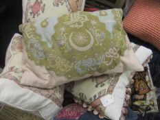 A box containing various scatter cushions decorated with various ethnic fabrics,