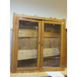 A Victorian pine two door display cabinet with three adjustable shelves