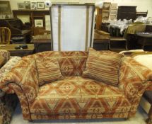 A two seater Chesterfield type sofa with red ground and yellow patterned upholstery,