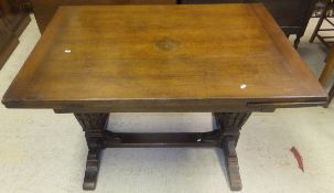 An oak draw leaf table on trestle style support