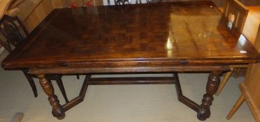 An oak parquetry inlaid draw leaf dining table with turned legs to stretchered base