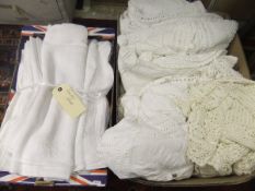 A box containing various linen bedding,