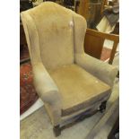 An early 20th Century wing back armchair with peach upholstery