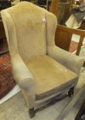 An early 20th Century wing back armchair with peach upholstery