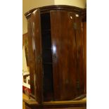 A 19th Century mahogany wall hanging corner cupboard of two doors enclosing four shelves and three