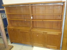 A two section pine bookcases with various adjustable shelves over two pairs of twin cupboard doors