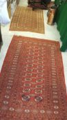 A Bokhara rug, the central orange ground decorated with elephant foot medallions within orange,