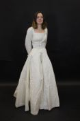 A 1950's wedding dress in lattice work decorated duchess satin,