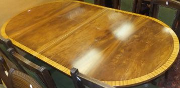 A reproduction Regency style mahogany twin pedestal dining table, crossbanded, in the manner of