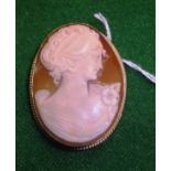 A 9 carat gold mounted shell cameo brooch decorated with bust of a young lady with ribbon in her