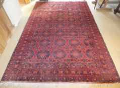 A Bokhara carpet, the central ground with repeating diamond and star shaped motifs in red, black,
