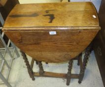 An oak drop leaf side table on barley-twist supports,