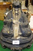 A 1920's lacquered papier maché speaker in the form of a seated Taoist scholar,
