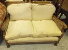 An early 20th Century suite of sofa and two chairs with mahogany frame and caned back and sides,