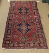A Caucasian rug, the two central diamond medallions in dark blue,