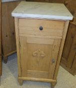 A pair of pine single door bedside cupboards with marble tops