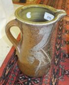 A Michael Casson mottled brown glazed jug of waisted form raised on four shaped feet CONDITION