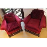 A pair of Carolean style deep seated armchairs with carving to the legs and front stretcher,