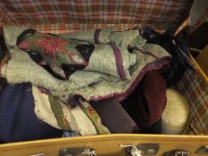 A vintage suitcase containing various mid 20th Century hats, a quilt, various handbags, etc.