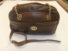 A suitcase containing a brown leather Gucci handbag,