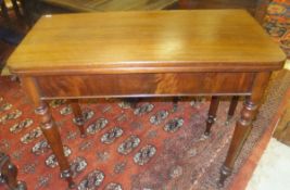 A Victoria mahogany foldover tea table on turned tapering legs