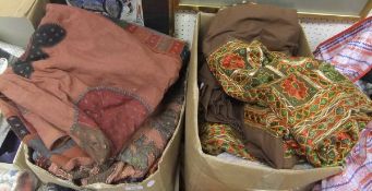 Two boxes containing assorted ethnic throws and pillow cases,