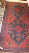 A Caucasian rug, the two central linked medallions in dark blue, red,