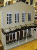 A painted wooden doll's house as a 19th Century draper's / haberdasher's shop