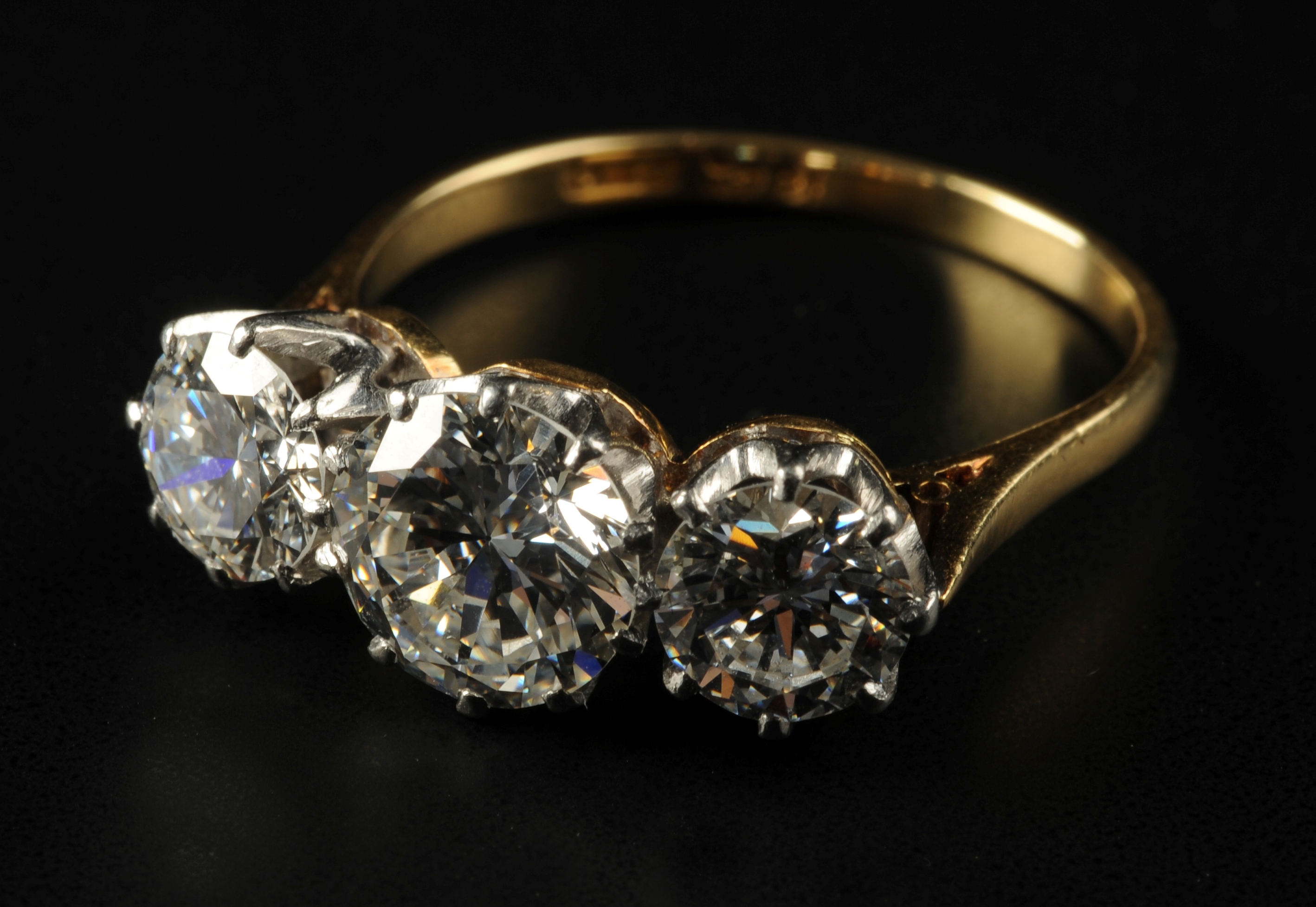 A THREE-STONE DIAMOND RING, the brillian