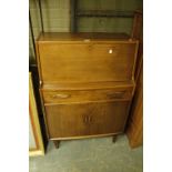 A 1970s teak bureau, having a drop front