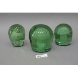 Three green glass dumps, each enclosing