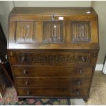 An oak bureau having a linen fold triple