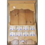 A pine spice rack with 8 ceramic drawers