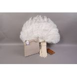 A snakeskin wallet, cream kid gloves, ostrich feather fan,