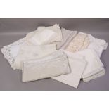 A quantity of ecru and ivory table linens including madeira style tablecloths,