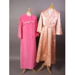 Two 1960s housecoats in shocking pink velvet with ribbon detail and in quilted peach satin