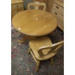 A modern small pine pedestal table and two beech framed chairs