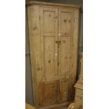 An early 19th century pine floor standing corner cupboard with double panelled doors enclosing a