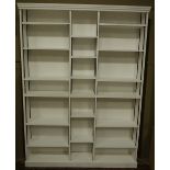 A modern white painted three section open bookcase;