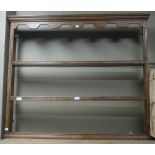 A small oak three tier plate rack with moulded cornice with a blind fret cut frieze