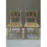 A pair of simulated bamboo painted side chairs with cane seats