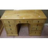 A pine desk with three frieze drawers, three further graduated drawers to each pedestal,