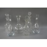 Three cut glass decanters, another in plain glass,