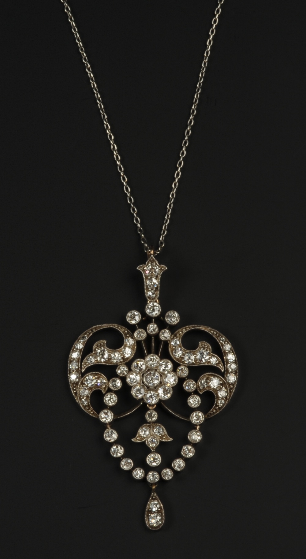 A BELLE EPOQUE DIAMOND PENDANT, in silver and 15ct gold,