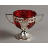 A WMF SILVER PLATED AND RED GLASS TWO HANDLED SUGAR BASKET,