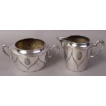 A WMF ART DECO DESIGN PLATED SUGAR BOWL with oval scroll relief decoration with double loop handles;